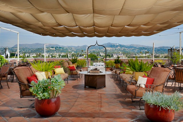 A beautiful, fruit tree-filled outdoor courtyard with plenty of comfortable chairs and a breathtaking view of LA.